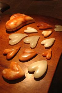 An array of white and orange Alabaster stone heart rocks